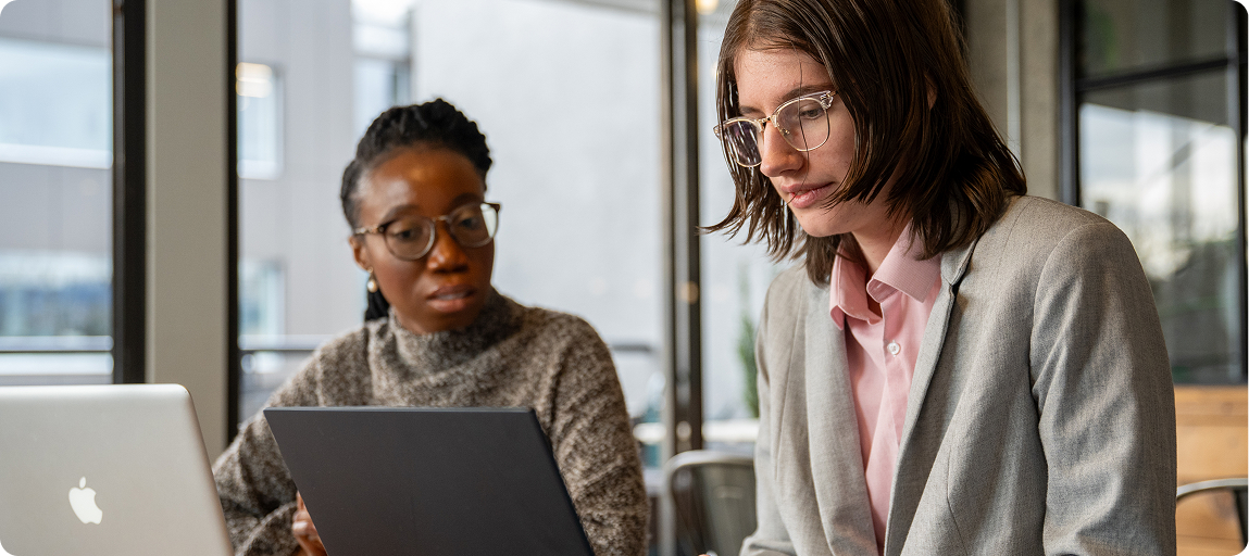 在卡里布，不同背景的人们围坐在一起使用笔记本电脑工作